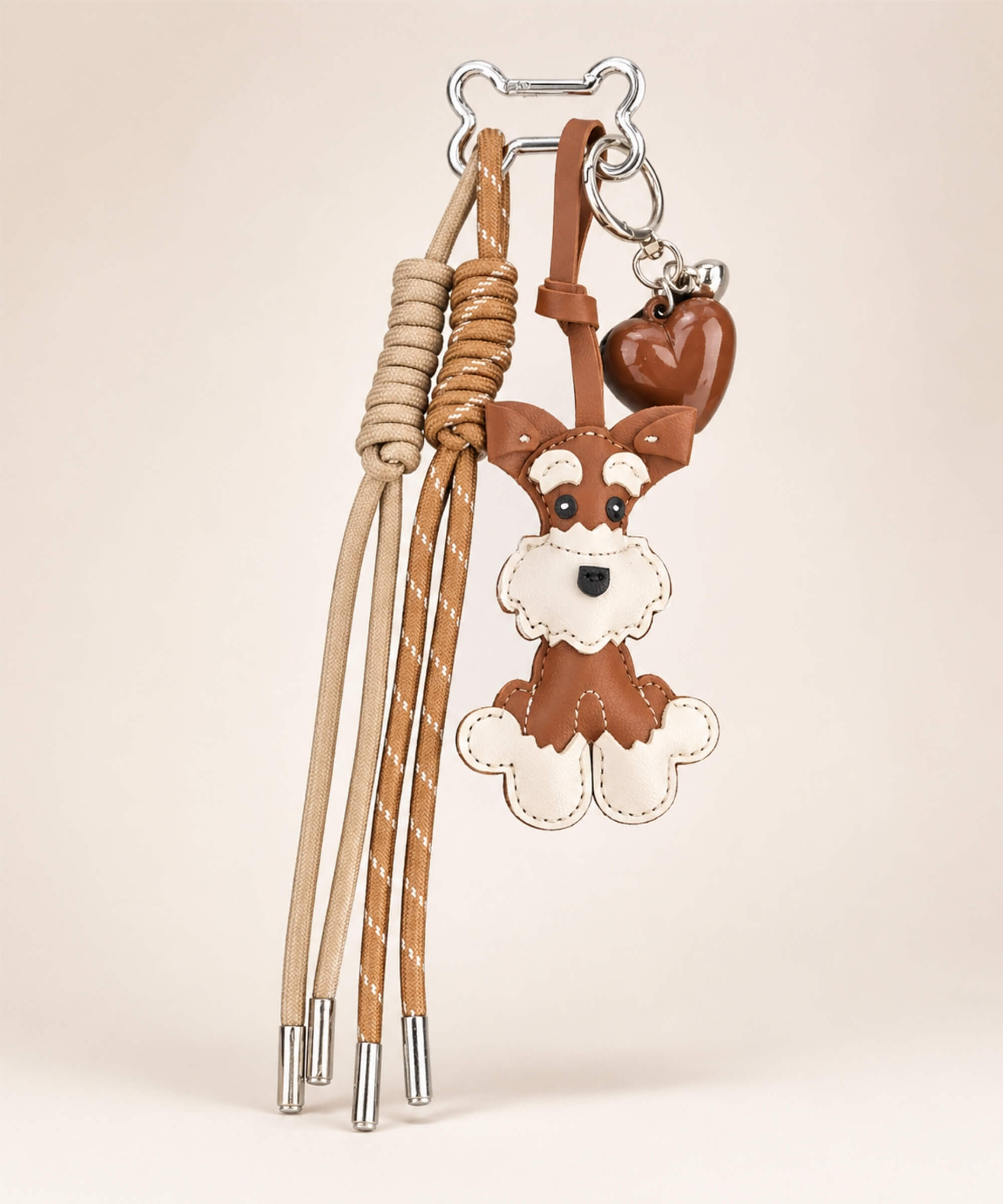 Brown Cute Schnauzer faux leather bag charm with heart pendant and tassel cords on a clean neutral background.
